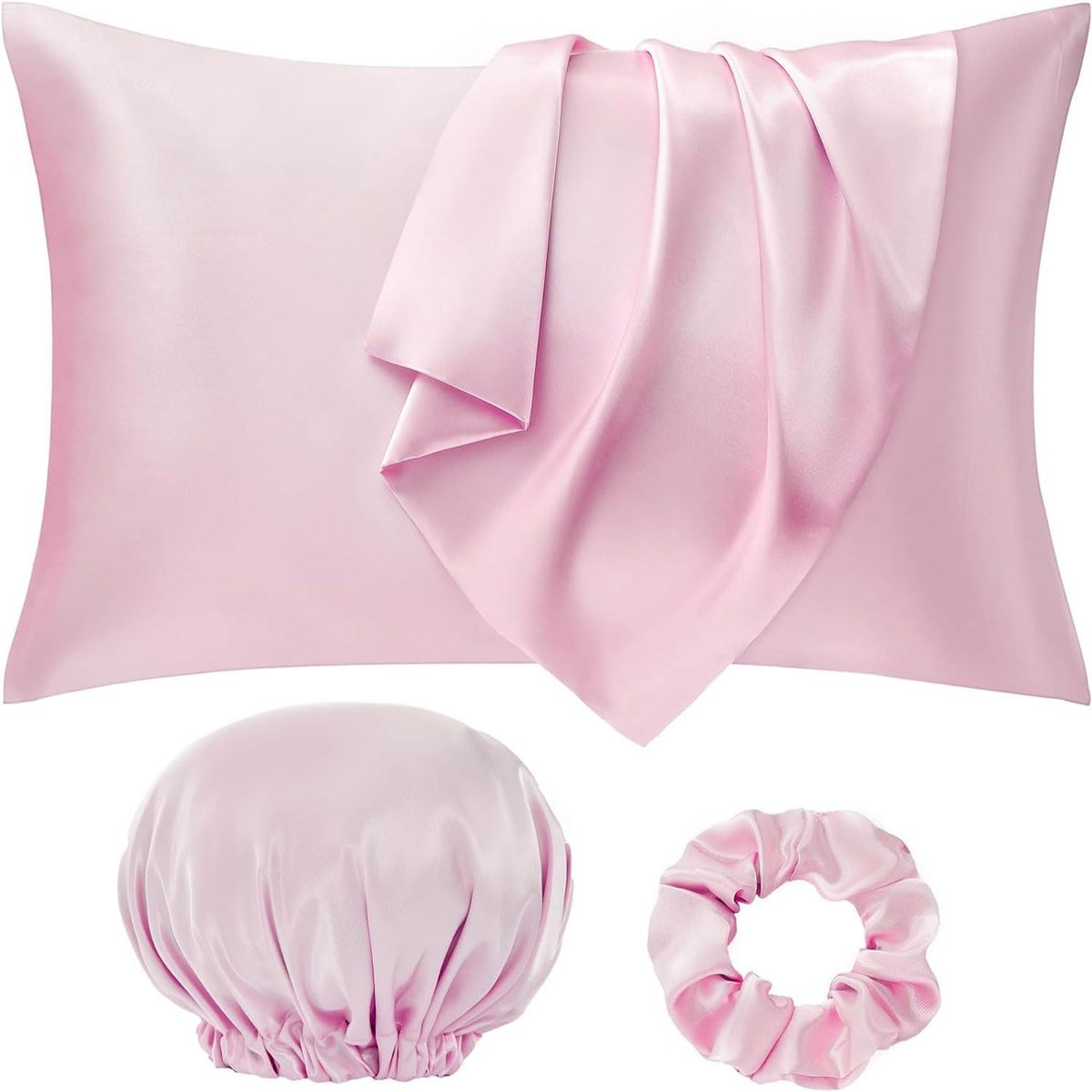 Set of pink satin pillowcase, bonnet, and scrunchie on a white background